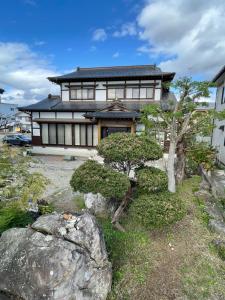 a house with trees in front of it at 暮らしやaizu in Kitakata