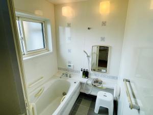a white bathroom with a tub and a sink at 暮らしやaizu in Kitakata +43 photos