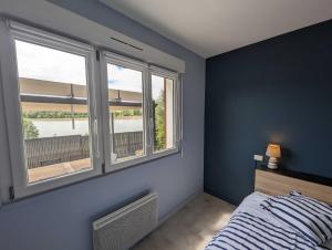 une chambre avec deux fenêtres et un lit dans l'établissement Le liez, à Peigney