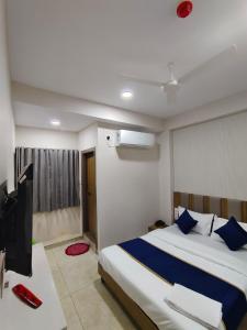 a bedroom with a large bed and a television at Hotel Metro in Himatnagar