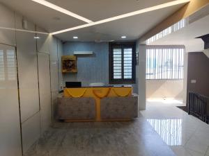 an office with a yellow desk in the middle of a room at Hotel Metro in Himatnagar