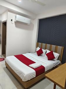 a bedroom with a large bed with red pillows at Hotel Metro in Himatnagar