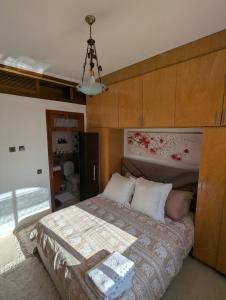 Appartement à 5 min de la plage, piscine et parking privé في بن سليمان: غرفة نوم بسرير كبير مع لوح رأس خشبي +12 صورة