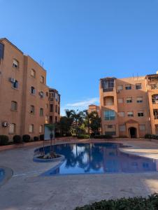 Appartement à 5 min de la plage, piscine et parking privé في بن سليمان: مسبح امام عمارتين