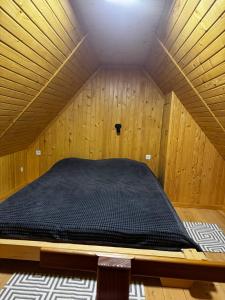 Будинок під Менчулом في راخيف: سرير في ساونا في غرفة خشبية +صورتان