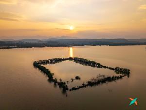 an island in the middle of a lake at sunset at Zostel Homes Kumta in Kumta