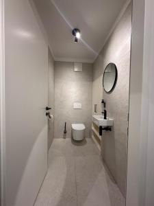 Modernes City Apartment inkl Garage und Balkon في لينز: حمام مزود بمرحاض ومغسلة ومرآة +17 صورة