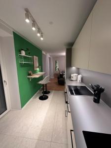 Modernes City Apartment inkl Garage und Balkon في لينز: مطبخ مع دواليب خضراء وبيضاء وطاولة