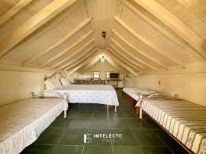 duas camas num quarto com telhado em Chácara c/ Piscina, Churrasqueira com vista linda em Poços de Caldas