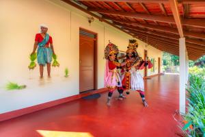 two women dressed in costumes standing in front of a house at Zostel Homes Kumta in Kumta +53 photos