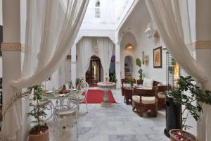 a living room with white curtains and a table and chairs at Riad Morocco Sky in Marrakesh