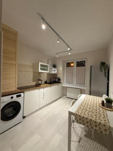 cocina con mesa y cocina con lavadora en Apartament dla 4 osób, en Świebodzice