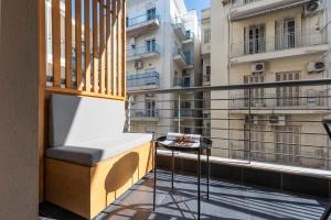 ein Balkon mit einer Bank und einem Tisch in der Unterkunft City Vibe Standard in Thessaloniki + 5 Fotos