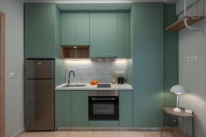 eine Küche mit grünen Schränken und einem Waschbecken in der Unterkunft City Vibe Standard in Thessaloniki
