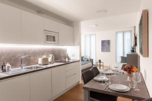 a kitchen with a table with wine glasses on it at The Golden Studio by Aura Luxury Collection in Como +14 photos