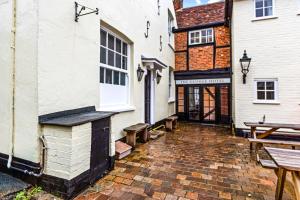 Un patio de un edificio con un banco al lado. en The George Inn, en Buckinghamshire