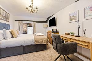 Un dormitorio con una cama, un escritorio y una silla. en The George Inn, en Buckinghamshire