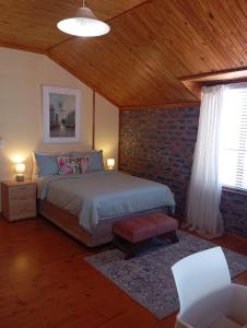 ein Schlafzimmer mit einem Bett und einer Ziegelwand in der Unterkunft Spacious Home, 2-Bed, 2-Bath, Braai Area, Parking in Witsand