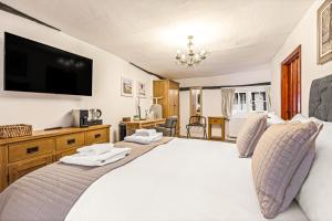 Un dormitorio con una cama grande y un televisor de pantalla plana. en The George Inn, en Buckinghamshire