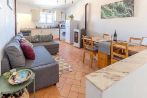 a living room and kitchen with a couch and a table at Casa Oceano-Mar a vista in Raposeira