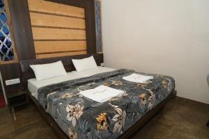 a bed in a room with two towels on it at SRT Rajmahal Famliy Hotel Luxa RoadVARANSHI in Varanasi