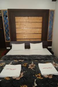 a bed with two white pillows on top of it at SRT Rajmahal Famliy Hotel Luxa RoadVARANSHI in Varanasi