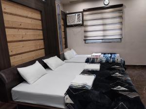 a room with two beds and a couch and a window at SRT Rajmahal Famliy Hotel Luxa RoadVARANSHI in Varanasi