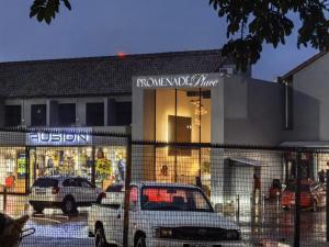 una macchina bianca parcheggiata di fronte a un negozio di Promenade Place Nelspruit a Nelspruit