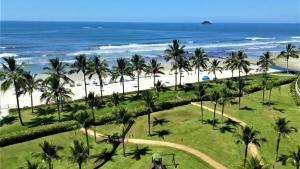 an aerial view of a beach with palm trees and the ocean at Apartamento Riviera na Praça das Artes Módulo 6 in Riviera de São Lourenço