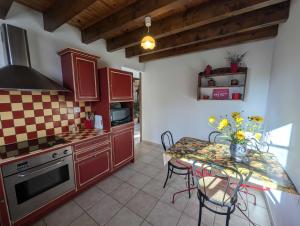 een keuken met rode kasten en een tafel met stoelen bij Gite du seminaire in Langres +29 foto's