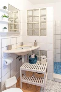 a white bathroom with a sink and a toilet at Casa Oceano-Mar a vista in Raposeira +37 photos