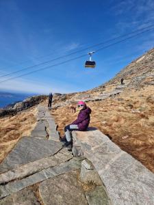 a person sitting on the edge of a rock ledge at Modern condominium in Bergen