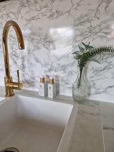 a kitchen sink with a vase with flowers in it at Modern condominium in Bergen