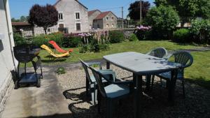 einen Tisch und Stühle sowie einen Spielplatz im Hof in der Unterkunft Les pivoines in Richebourg