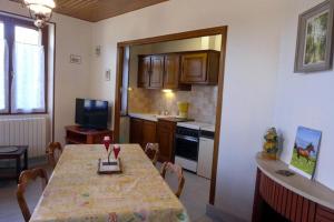 eine Küche mit einem Tisch und eine Küche mit einem Tisch und Stühlen in der Unterkunft Les pivoines in Richebourg