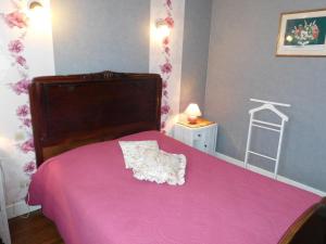 ein Schlafzimmer mit einem rosa Bett mit einer rosa Decke in der Unterkunft Les pivoines in Richebourg