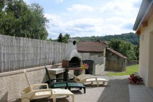 eine Terrasse mit einem Pizzaofen im Hinterhof in der Unterkunft Le cedre bleu in Goncourt