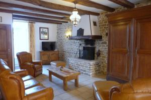 ein Wohnzimmer mit Sofa und Kamin in der Unterkunft Le cedre bleu in Goncourt
