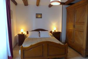 ein Schlafzimmer mit einem großen Bett mit zwei nebeneinander liegenden Lampen in der Unterkunft Le cedre bleu in Goncourt