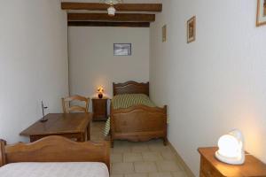 a bedroom with two beds and a table and a desk at Le cèdre bleu in Goncourt +2 photos