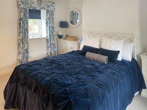 una camera da letto con un grande letto blu con cuscini di Shearwaters a Saint Mawes