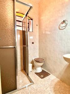 um banheiro com chuveiro, vaso sanitário e pia em Chácara c/ Piscina, Churrasqueira com vista linda em Poços de Caldas mais 34 fotografias