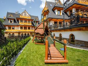 a house with a staircase in front of it at TatryTop Zakopiańskie Tarasy Premium & SPA in Zakopane