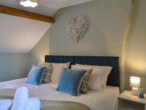 a bedroom with a bed with blue and white pillows at Peace Cottage in Flamborough +12 photos
