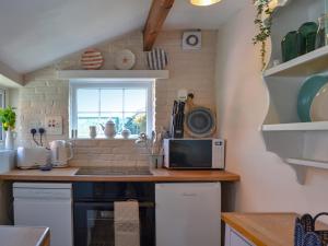 a kitchen with a counter top with a microwave at Peace Cottage in Flamborough