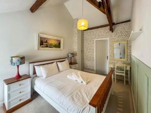 1 dormitorio con 1 cama, 1 mesa y 1 lámpara en Lodge Yard Barn, en Roecliffe 6 fotos más