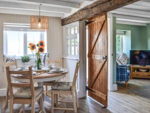 a dining room with a table and a barn door at Peace Cottage in Flamborough