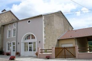 ein großes weißes Haus mit einem Holzzaun in der Unterkunft Le paradis des goncourt in Goncourt