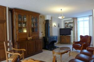 ein Wohnzimmer mit Kamin, Couch und Tisch in der Unterkunft Le paradis des goncourt in Goncourt