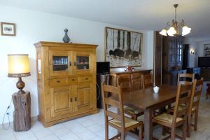 ein Esszimmer mit einem Tisch und einem Holzschrank in der Unterkunft Le paradis des goncourt in Goncourt